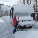 Standing outside the RV with skis