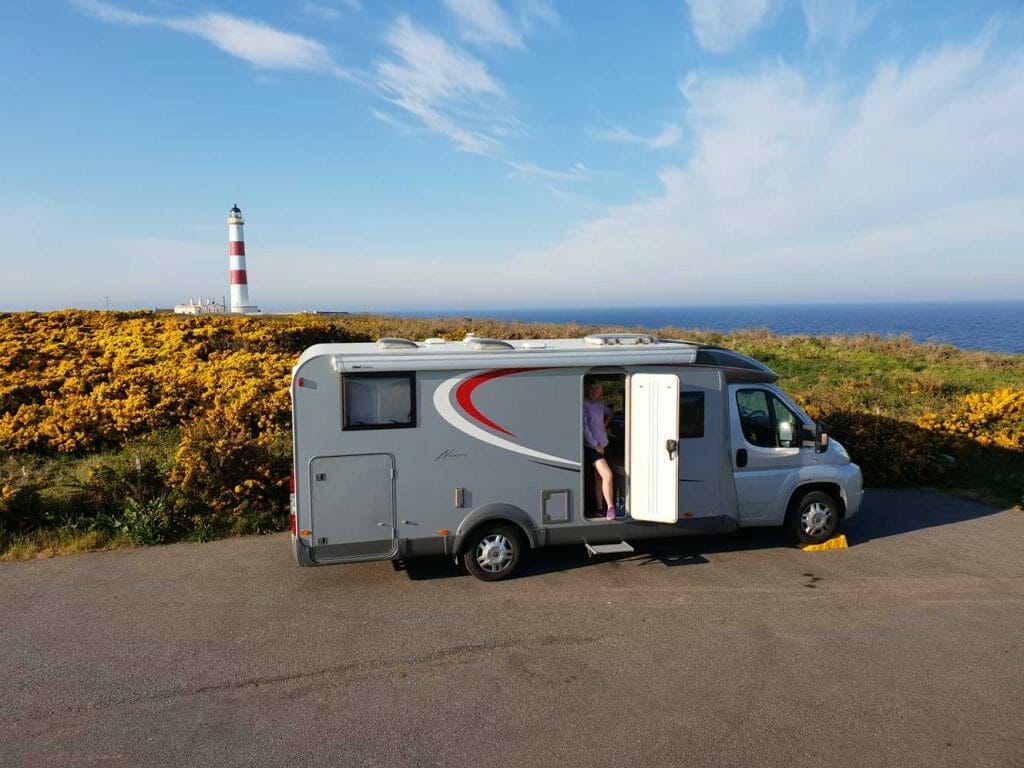 Our motorhome with lighthouse in background on our Scottish road trip