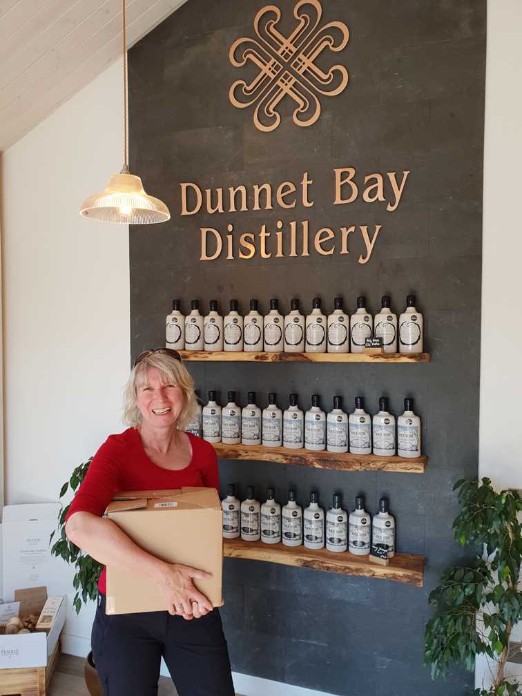 Me holding a box of gin outside the Dunnet Bay gin distillery
