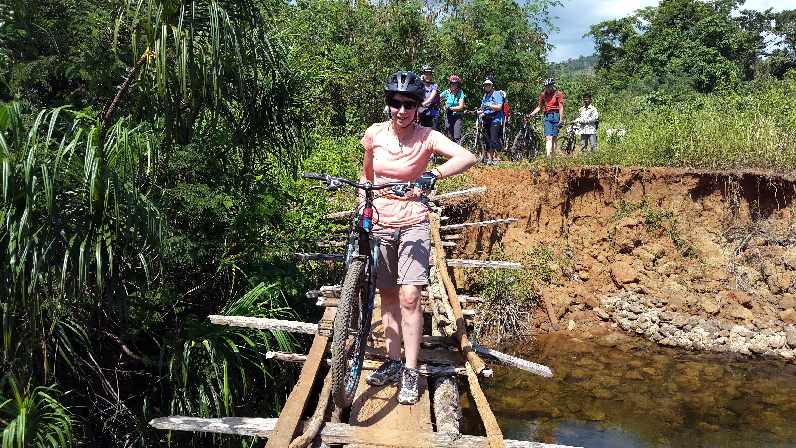 Jane crossing bridge with bike
