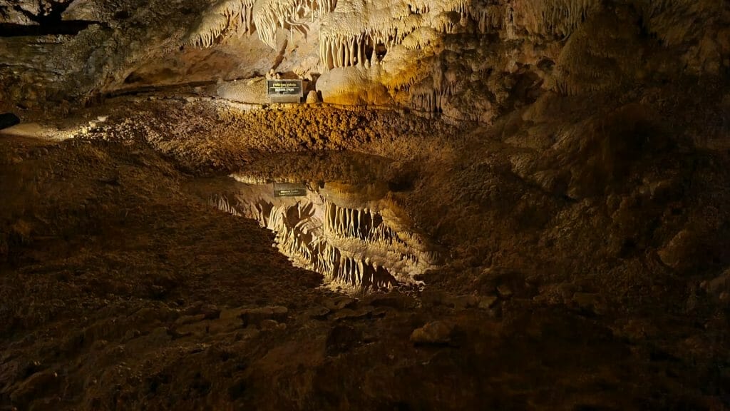 Mirror Lake inside Carlsbad Caverns. Sign reflected in the water