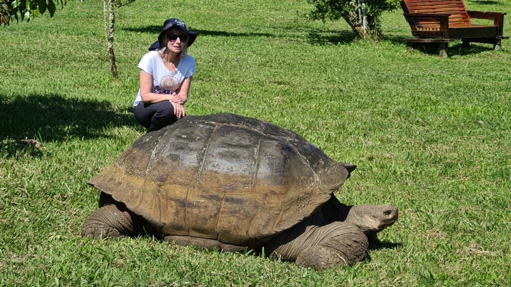 Jane by giant tortoise on trip to the Galapagos Islands