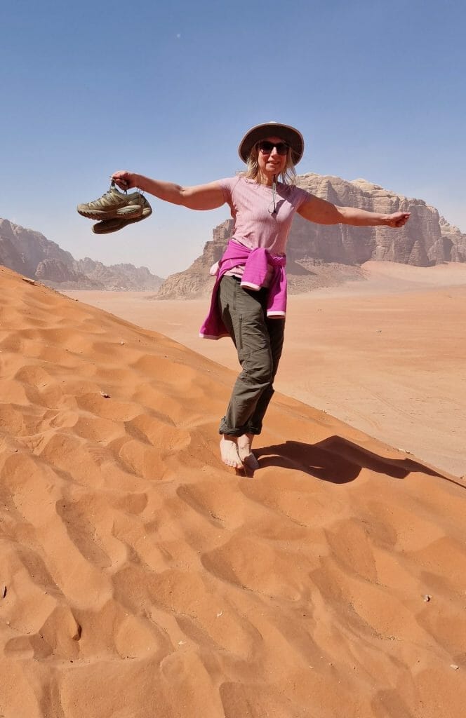 Jane running down sand dune in Wadi Rum in bare feet