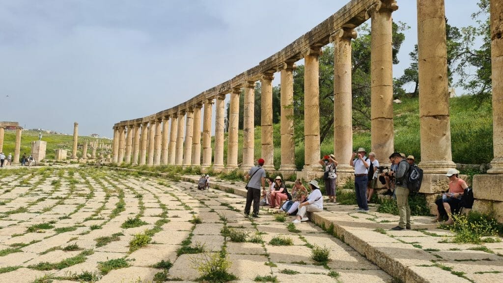 People sitting in the oval plaza inside Jerash